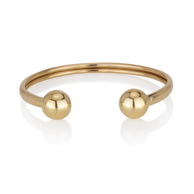 An open bracelet with two solid gold balls